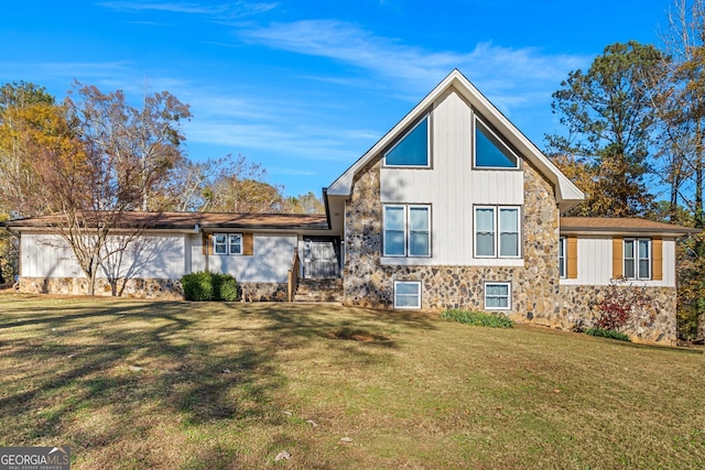 view of front facade with stone siding and a front yard