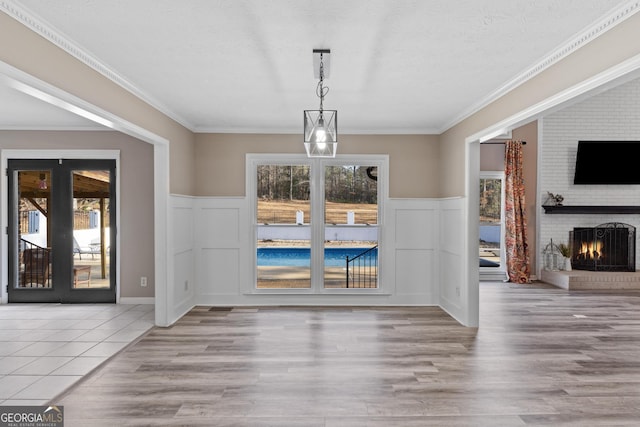 unfurnished dining area featuring a brick fireplace, plenty of natural light, and a textured ceiling