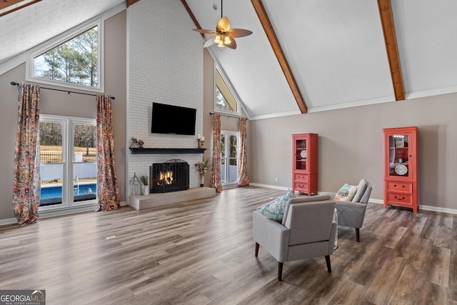 living room with high vaulted ceiling, a brick fireplace, dark hardwood / wood-style flooring, a wealth of natural light, and beamed ceiling