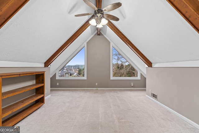 bonus room featuring ceiling fan, light colored carpet, lofted ceiling, and a textured ceiling