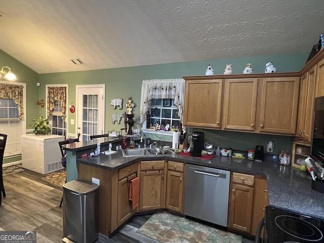 kitchen with vaulted ceiling, dishwasher, sink, kitchen peninsula, and dark wood-type flooring