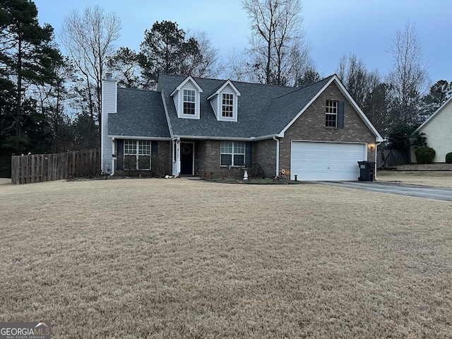 cape cod home with a garage and a front lawn