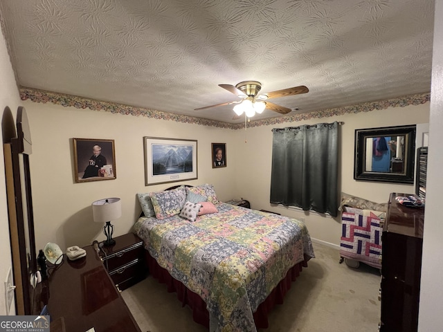 bedroom with ceiling fan, light colored carpet, and a textured ceiling