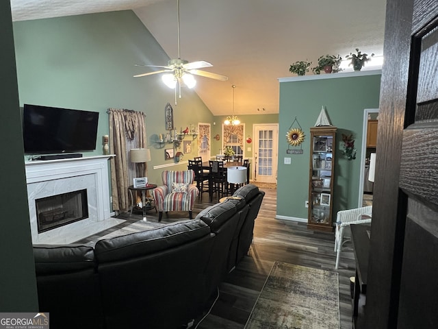 living room with ceiling fan with notable chandelier, a fireplace, high vaulted ceiling, and dark hardwood / wood-style floors