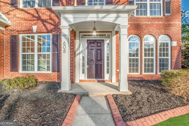 view of exterior entry featuring brick siding