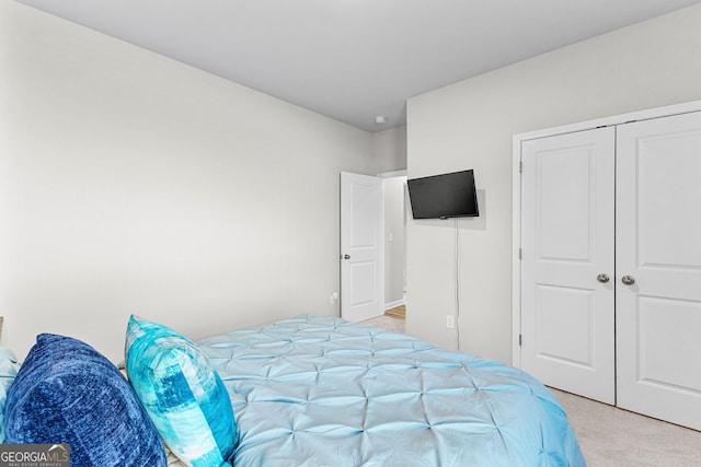 bedroom featuring light carpet and a closet