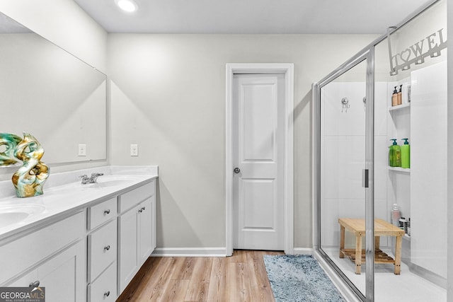 bathroom with hardwood / wood-style flooring, vanity, and a shower with shower door