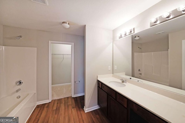 bathroom featuring wood-type flooring, vanity, and  shower combination