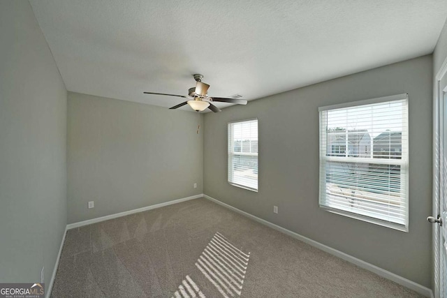 unfurnished room featuring ceiling fan, carpet, and a textured ceiling