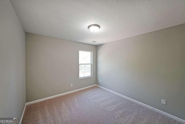 unfurnished room featuring carpet flooring and a textured ceiling