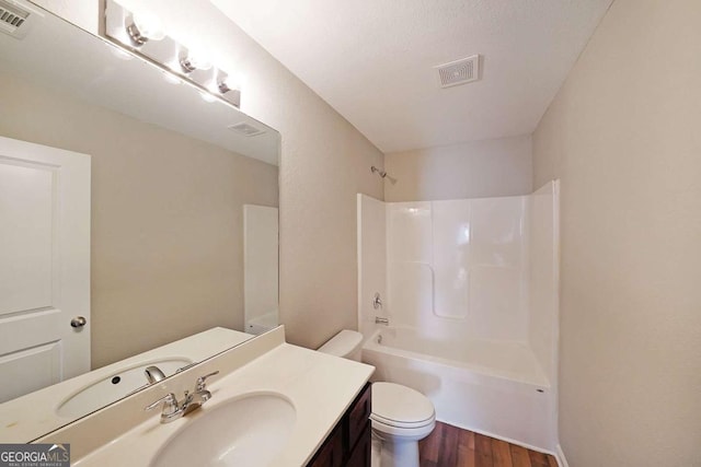 full bathroom featuring vanity, toilet, hardwood / wood-style floors, and shower / bathing tub combination