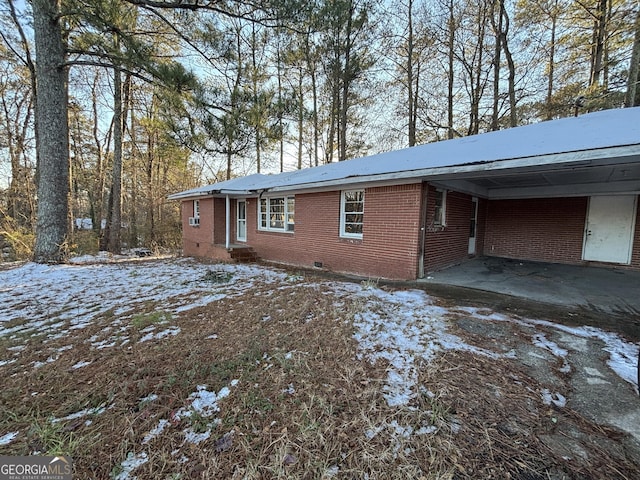 view of snowy exterior with a carport