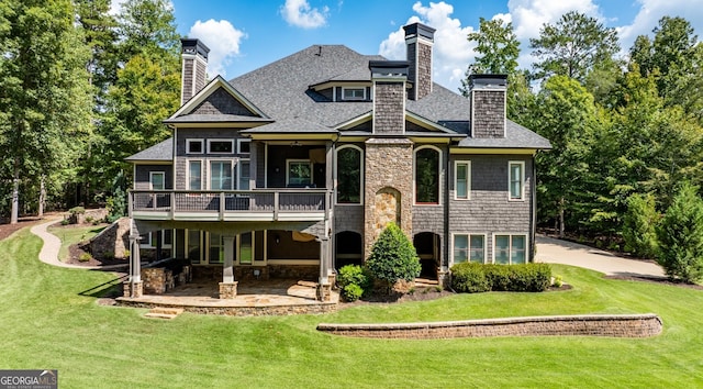 back of house featuring a wooden deck, a yard, and a patio area