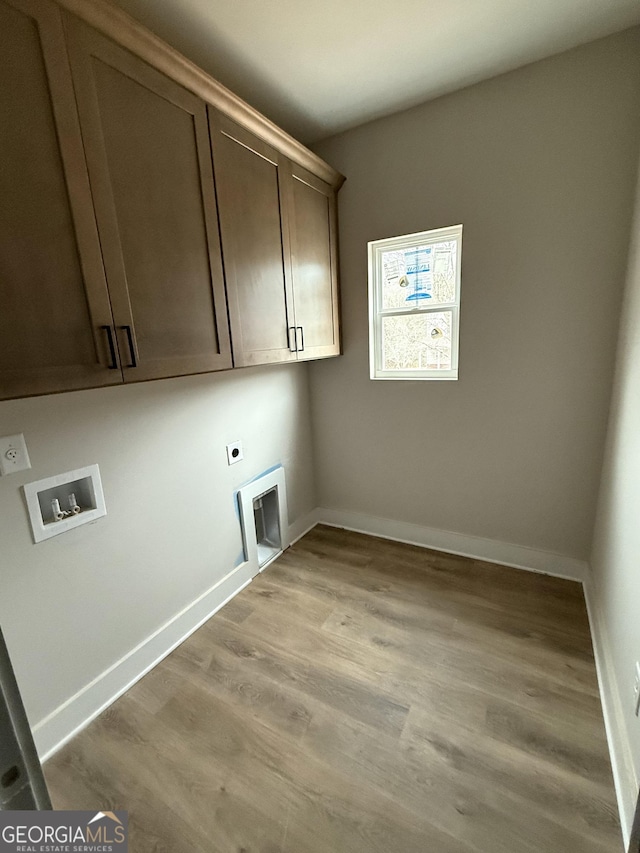 washroom featuring washer hookup, cabinet space, light wood finished floors, baseboards, and hookup for an electric dryer