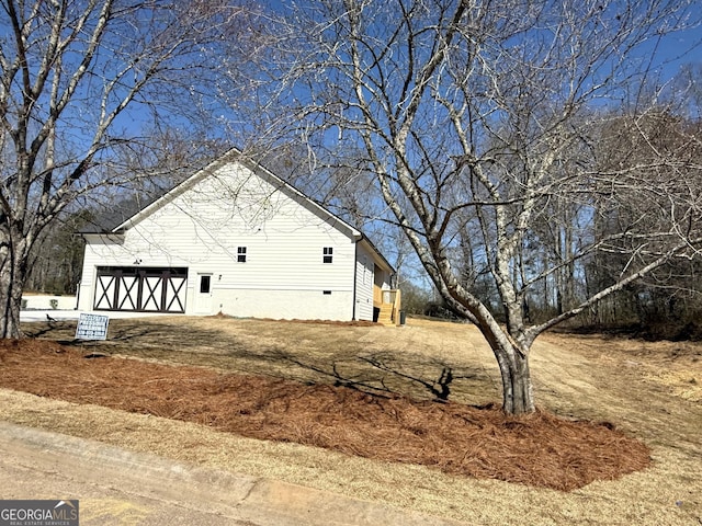 view of property exterior with crawl space and a garage