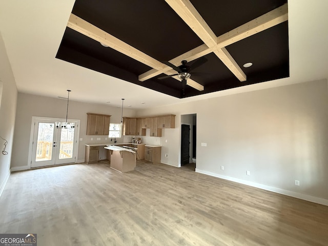 interior space with a ceiling fan, baseboards, coffered ceiling, light wood-style floors, and beamed ceiling