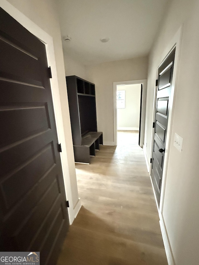 hall with light wood finished floors and baseboards