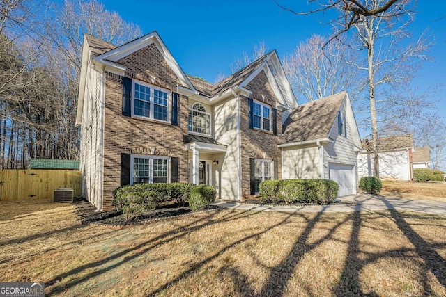 view of front of property featuring a garage, central AC, and a front yard