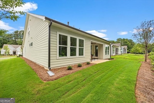 rear view of property with a patio and a yard