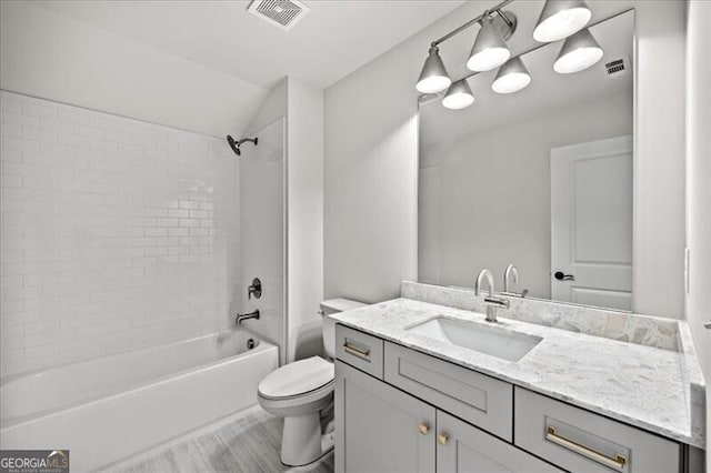 full bathroom featuring lofted ceiling, tiled shower / bath combo, vanity, wood-type flooring, and toilet