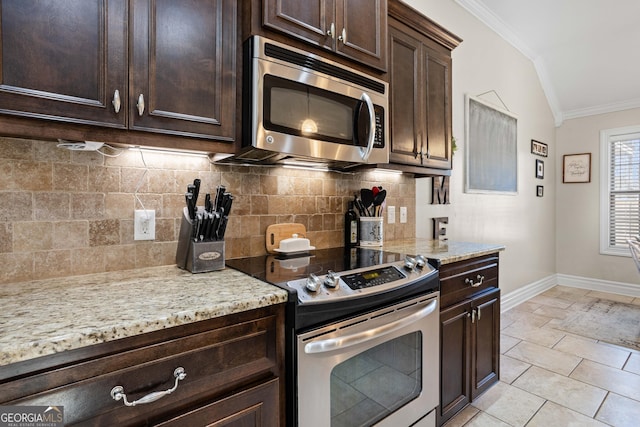 kitchen featuring dark brown cabinets, ornamental molding, stainless steel appliances, light stone countertops, and decorative backsplash