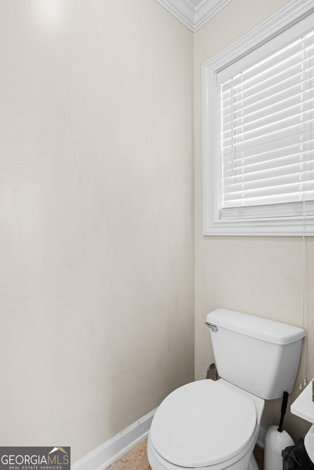 bathroom with ornamental molding and toilet