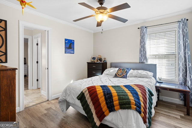 bedroom featuring crown molding, light hardwood / wood-style flooring, and ceiling fan