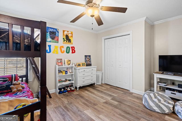 bedroom featuring crown molding, a closet, ceiling fan, and light hardwood / wood-style flooring