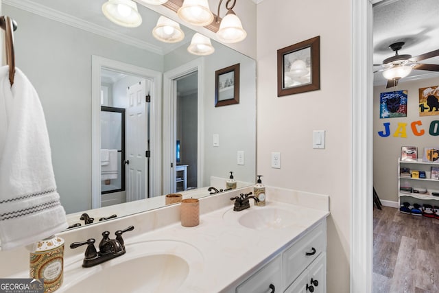 bathroom with hardwood / wood-style flooring, ceiling fan, ornamental molding, and vanity