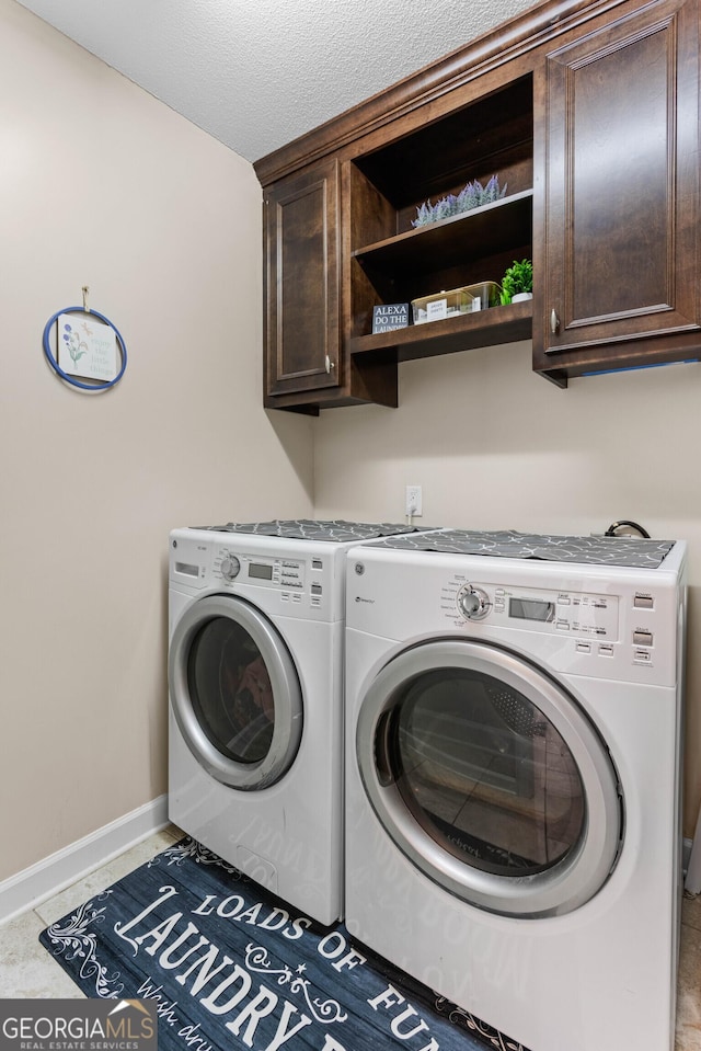 laundry room with cabinets, separate washer and dryer, and a textured ceiling