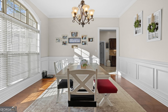 dining area with crown molding, hardwood / wood-style floors, and a notable chandelier