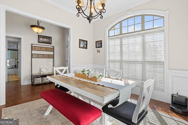 dining room featuring ornamental molding, dark wood-type flooring, and an inviting chandelier