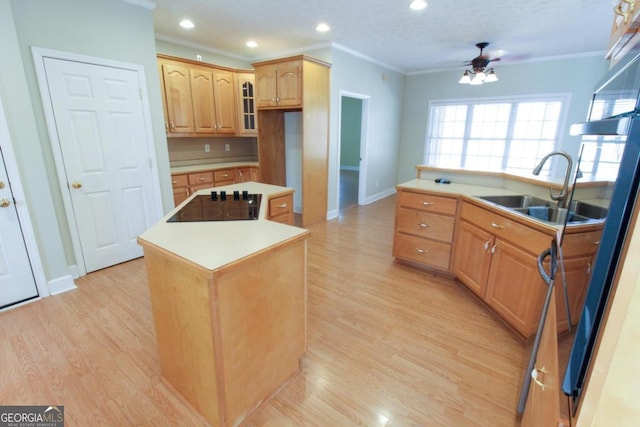 kitchen featuring sink, crown molding, a center island with sink, light wood-type flooring, and black electric stovetop