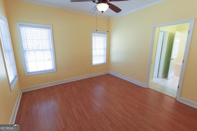 spare room featuring ceiling fan, ornamental molding, and wood-type flooring