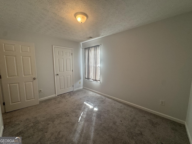 unfurnished bedroom featuring carpet floors and a textured ceiling