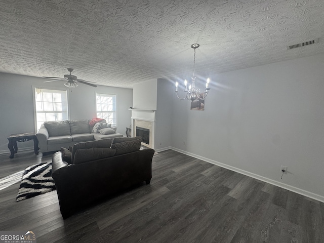 living room featuring ceiling fan with notable chandelier, a textured ceiling, and dark hardwood / wood-style flooring