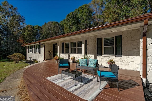 wooden terrace with an outdoor living space