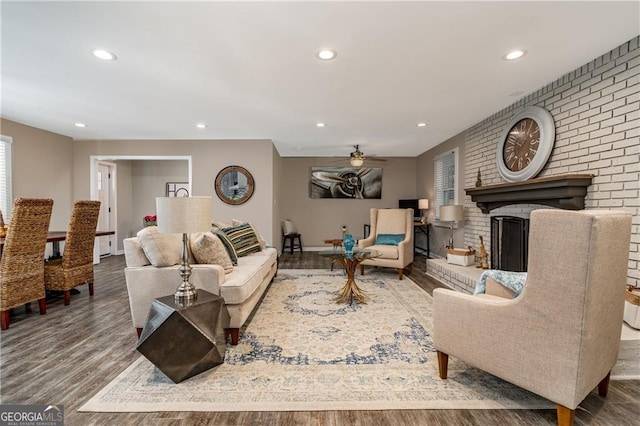 living room with ceiling fan, hardwood / wood-style floors, and a fireplace