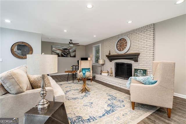 living room featuring ceiling fan, a fireplace, and hardwood / wood-style floors