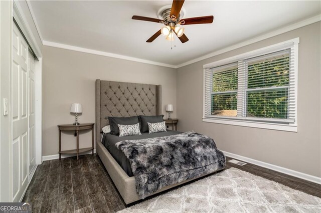 bedroom featuring dark hardwood / wood-style flooring, ornamental molding, a closet, and ceiling fan