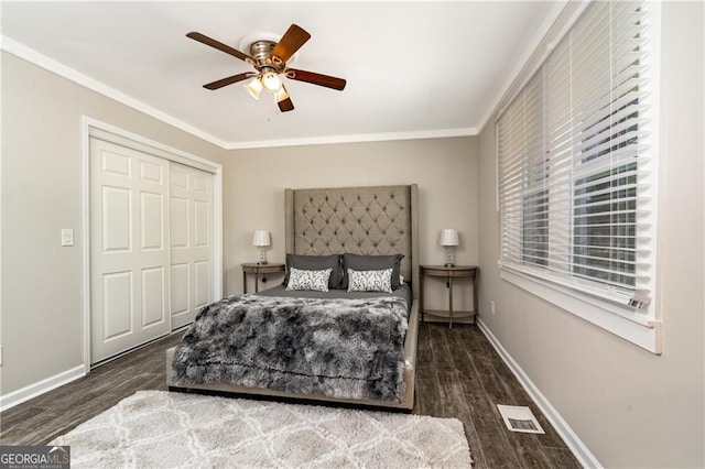 bedroom featuring a closet, crown molding, dark hardwood / wood-style floors, and ceiling fan