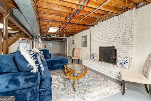 living room featuring a fireplace, concrete flooring, and water heater