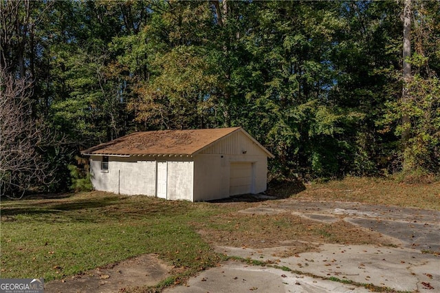 view of outbuilding with a garage and a lawn