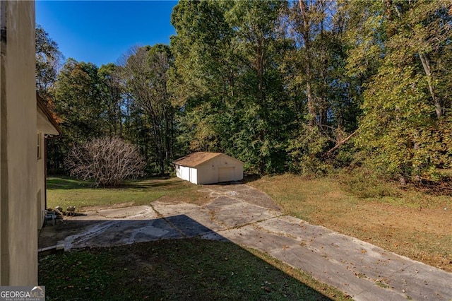 view of yard featuring a garage and an outbuilding