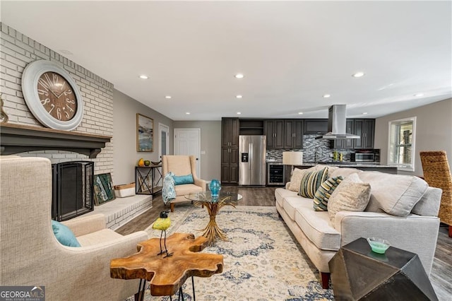 living room featuring wood-type flooring, beverage cooler, and a fireplace