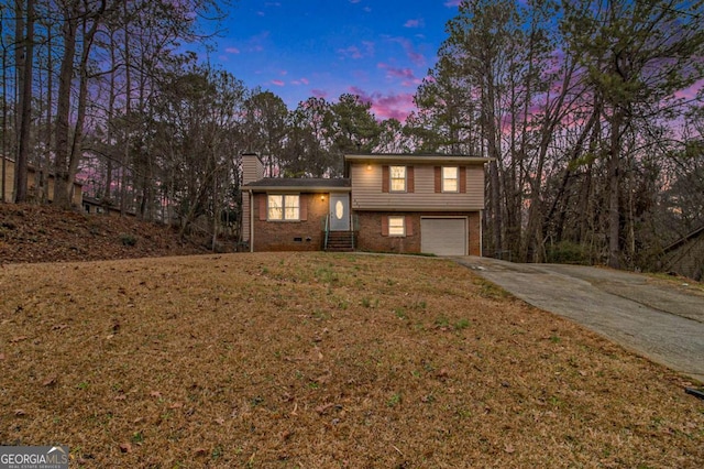 view of front of property featuring a garage and a lawn