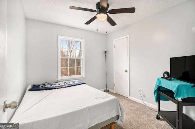 carpeted bedroom featuring ceiling fan and a textured ceiling