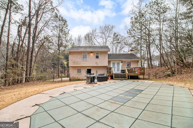 back of property featuring a pool side deck and a patio