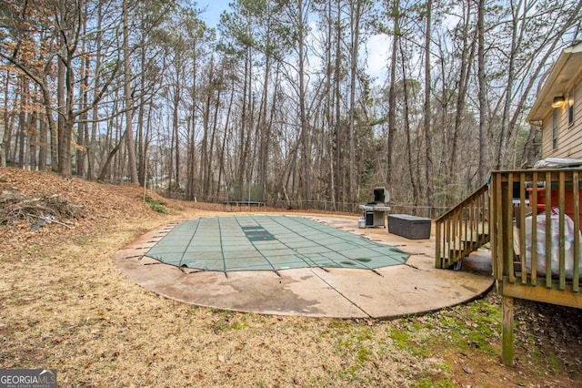 view of pool with area for grilling and a patio