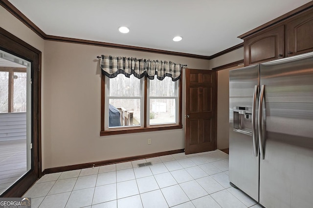 kitchen with crown molding, dark brown cabinetry, stainless steel fridge with ice dispenser, and plenty of natural light